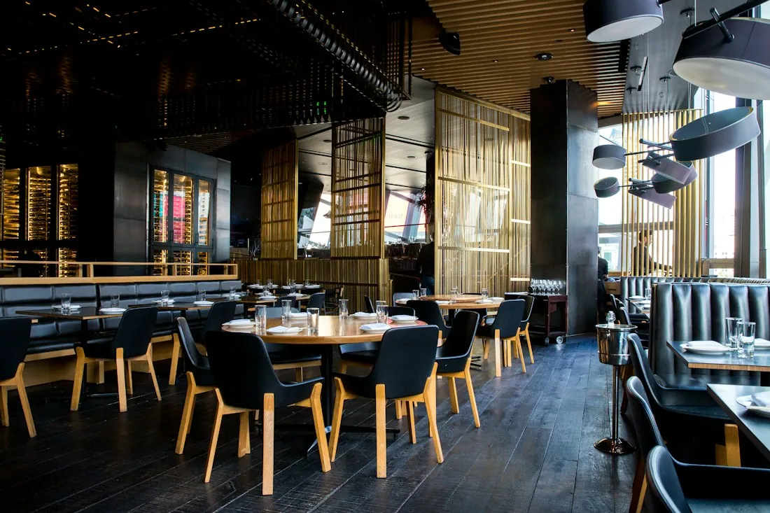 Warm restaurant interior with wooden tables and pendant lights